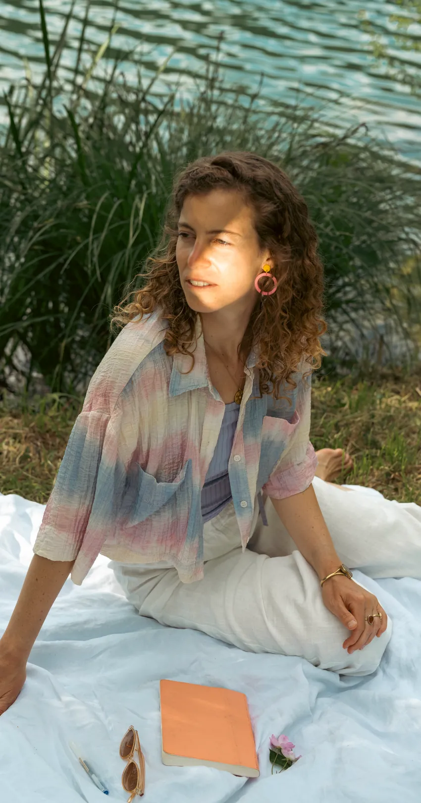 Nora Milena sitzt lächelnd im Gras