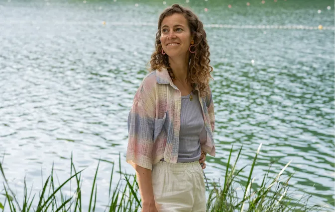 Nora Milena steht lächelnd am Wasser